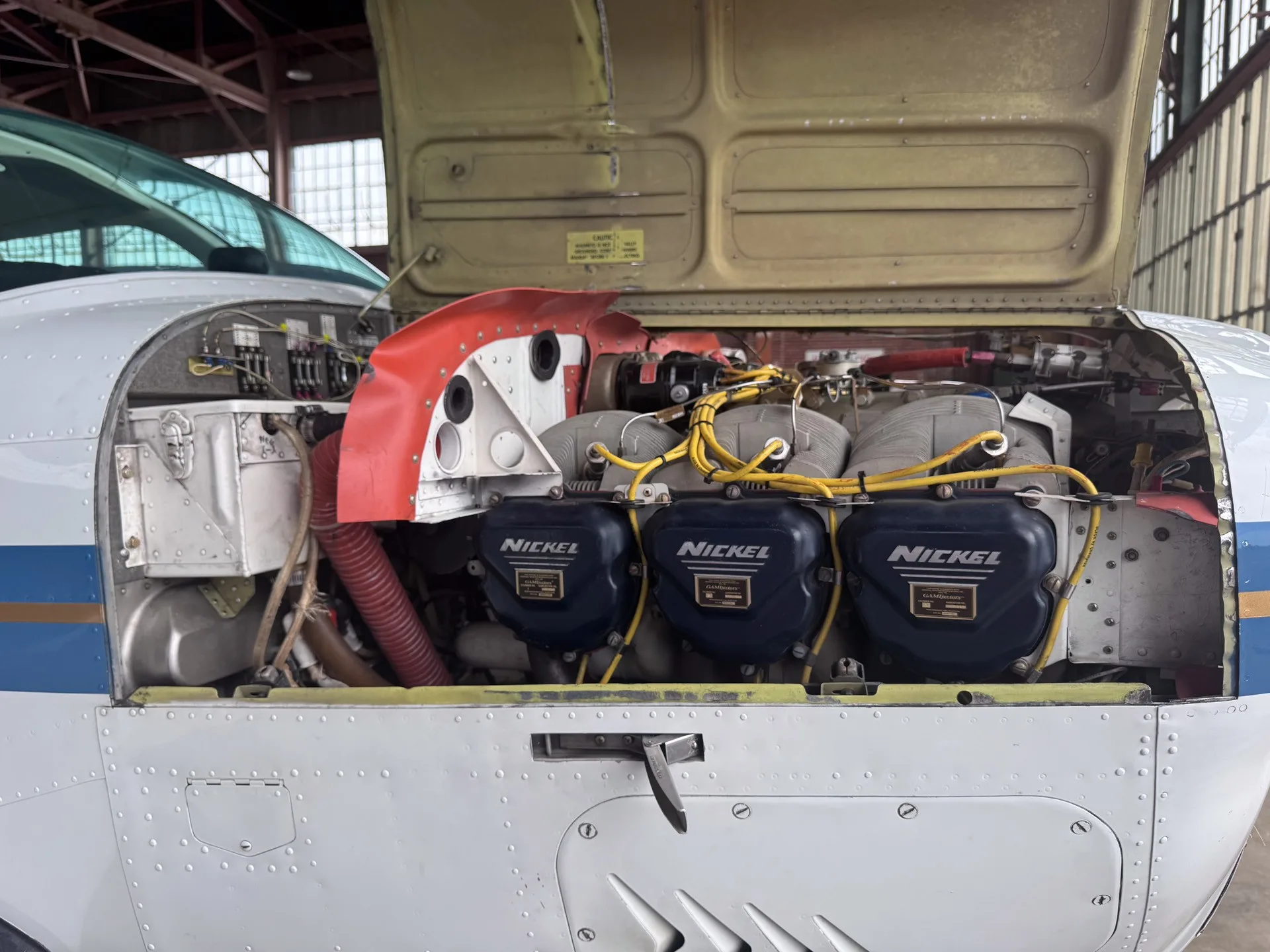 Another view of the aircraft's engine compartment with the cowling open, showing internal components.