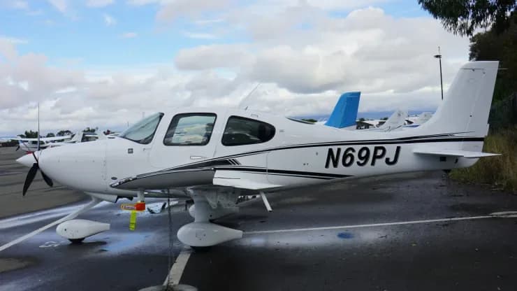 A Cirrus aircraft with registration N69PJ parked on the tarmac.