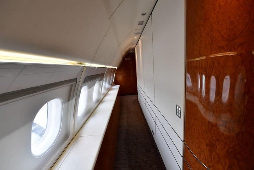 Interior of the aircraft with windows and a hallway.