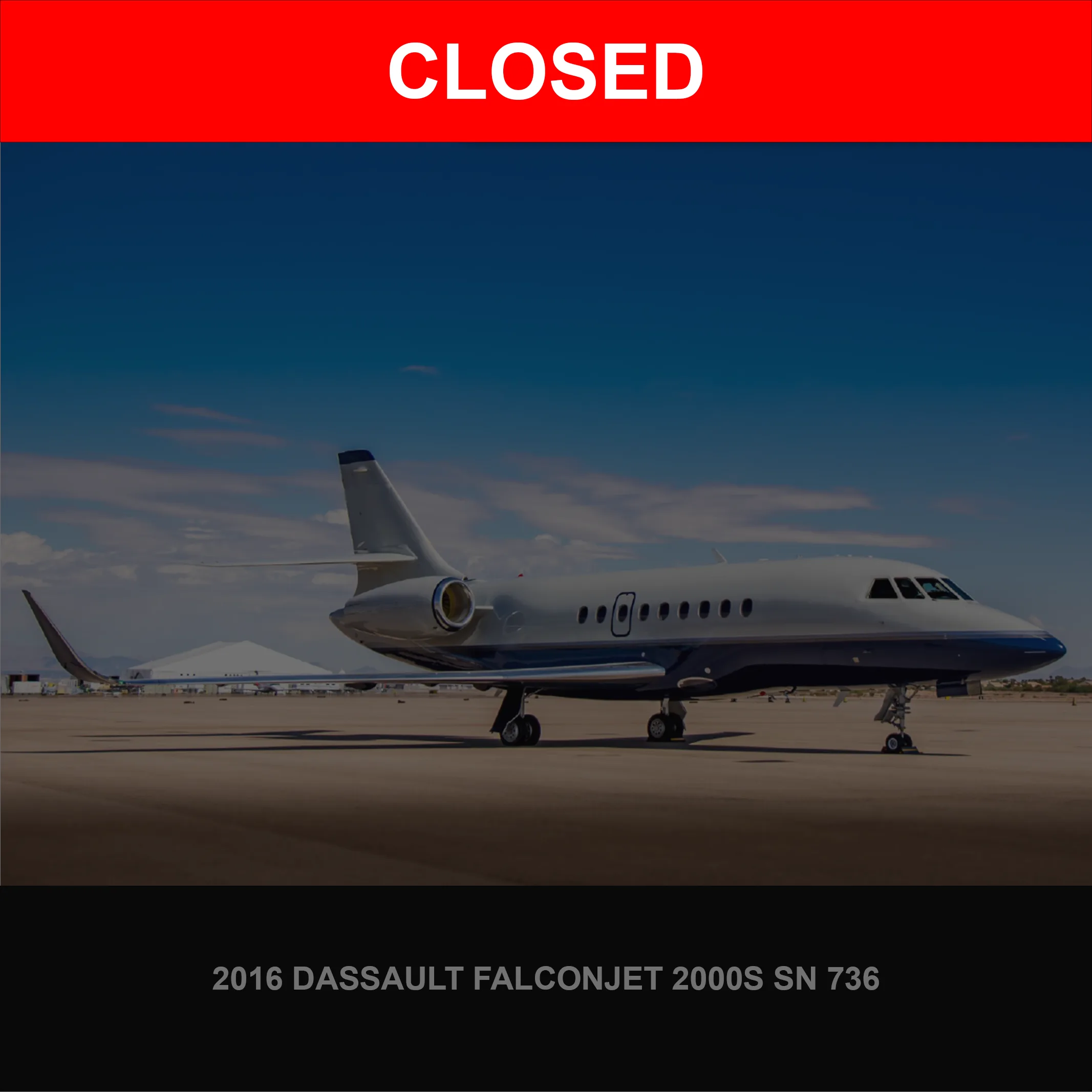 A 2016 Dassault Falconjet 2000S, painted white and blue, parked on an airport tarmac under a clear sky.