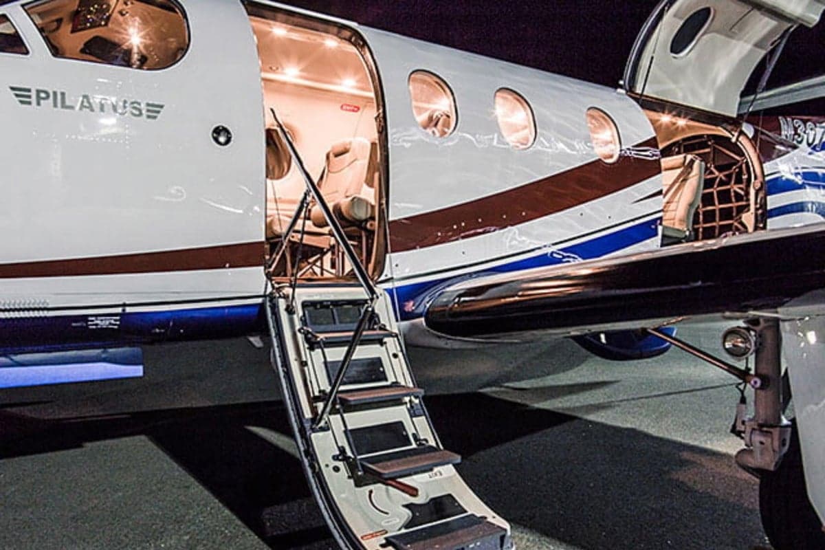 Exterior view of the Pilatus aircraft with the door open and stairs extended.