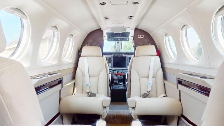 Interior view of a King Air aircraft cabin with cream-colored leather seats.