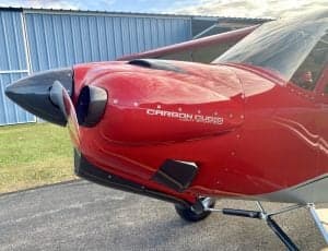 Close-up of the nose of the red Carbon Cub N7XU, showing the Carbon Cub logo.