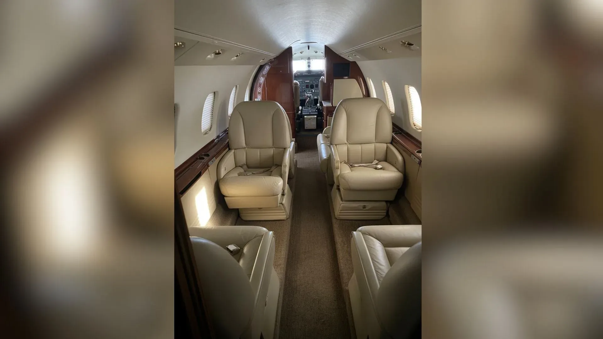 The interior of the aircraft features cream-colored leather seats.