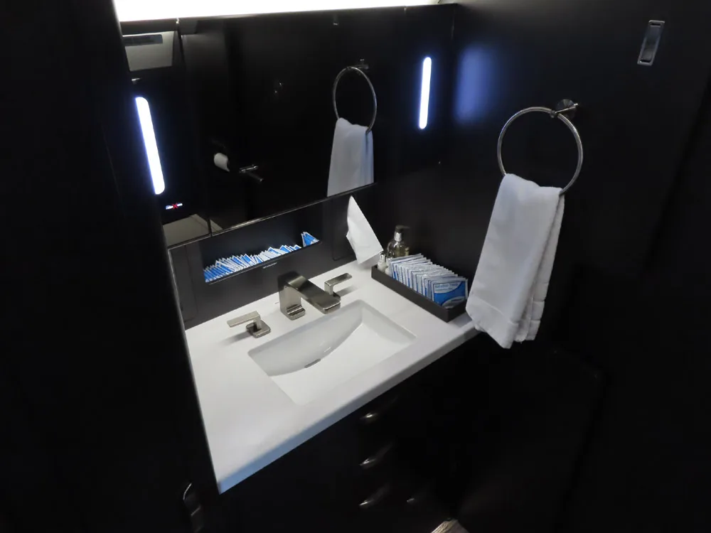 Aircraft lavatory with a sink and mirror.