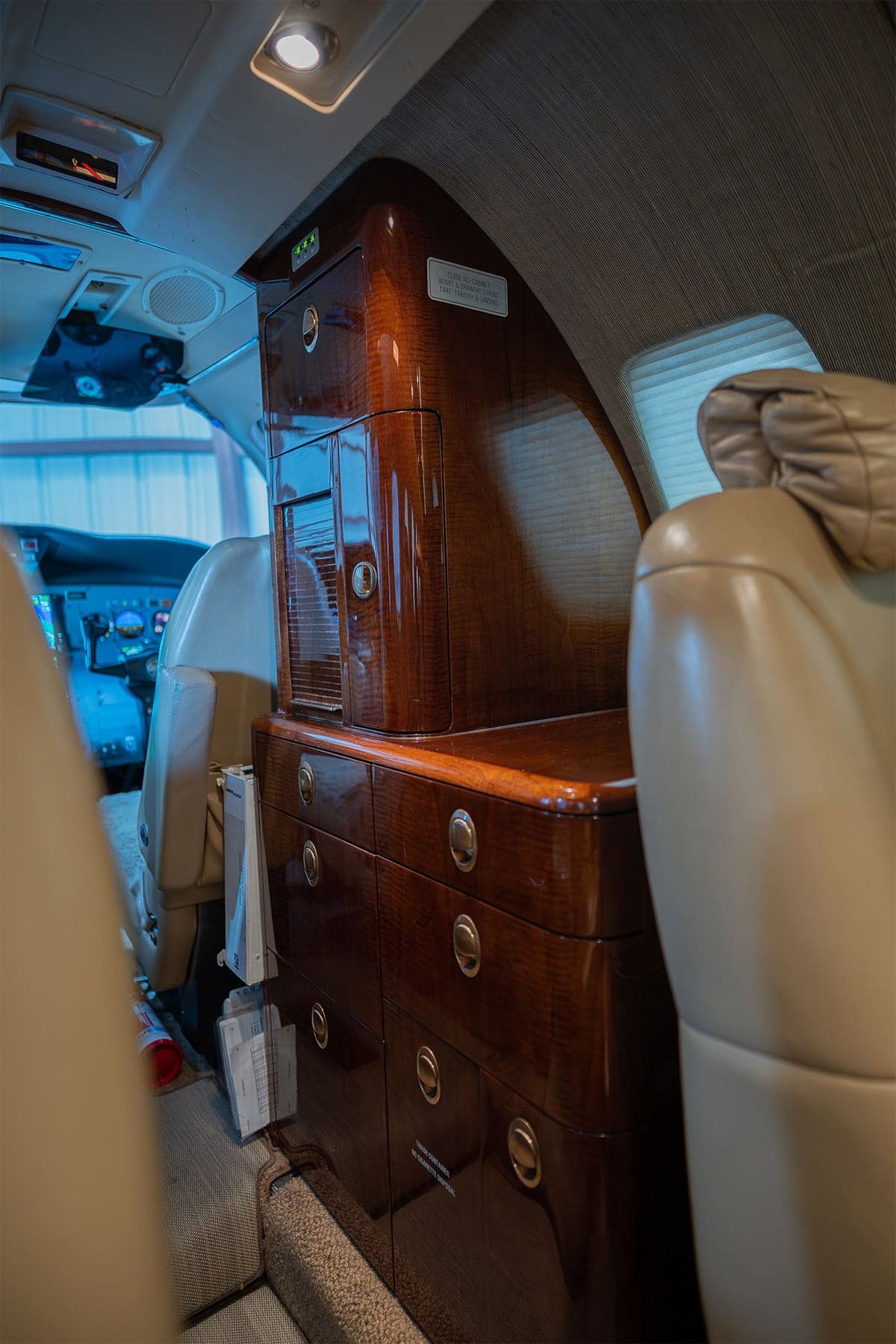 View of the aircraft interior showing a wooden cabinet and seats.