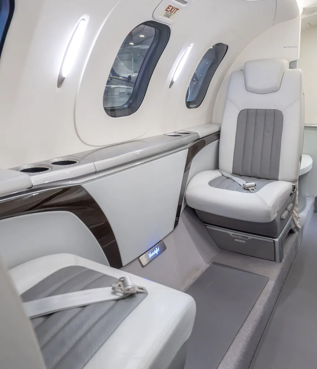 A close-up view of a white and grey leather passenger seat inside the HondaJet HA-420 cabin.