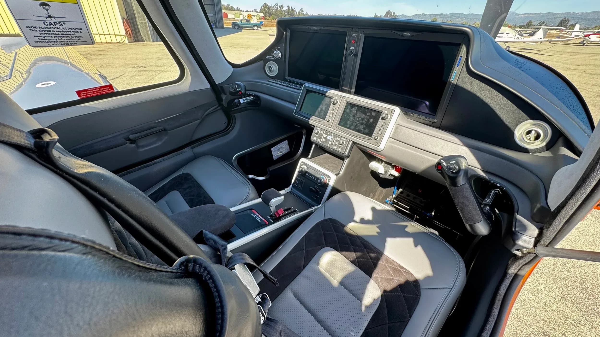 View of the cockpit of a Cirrus SR22 with gray leather seats.