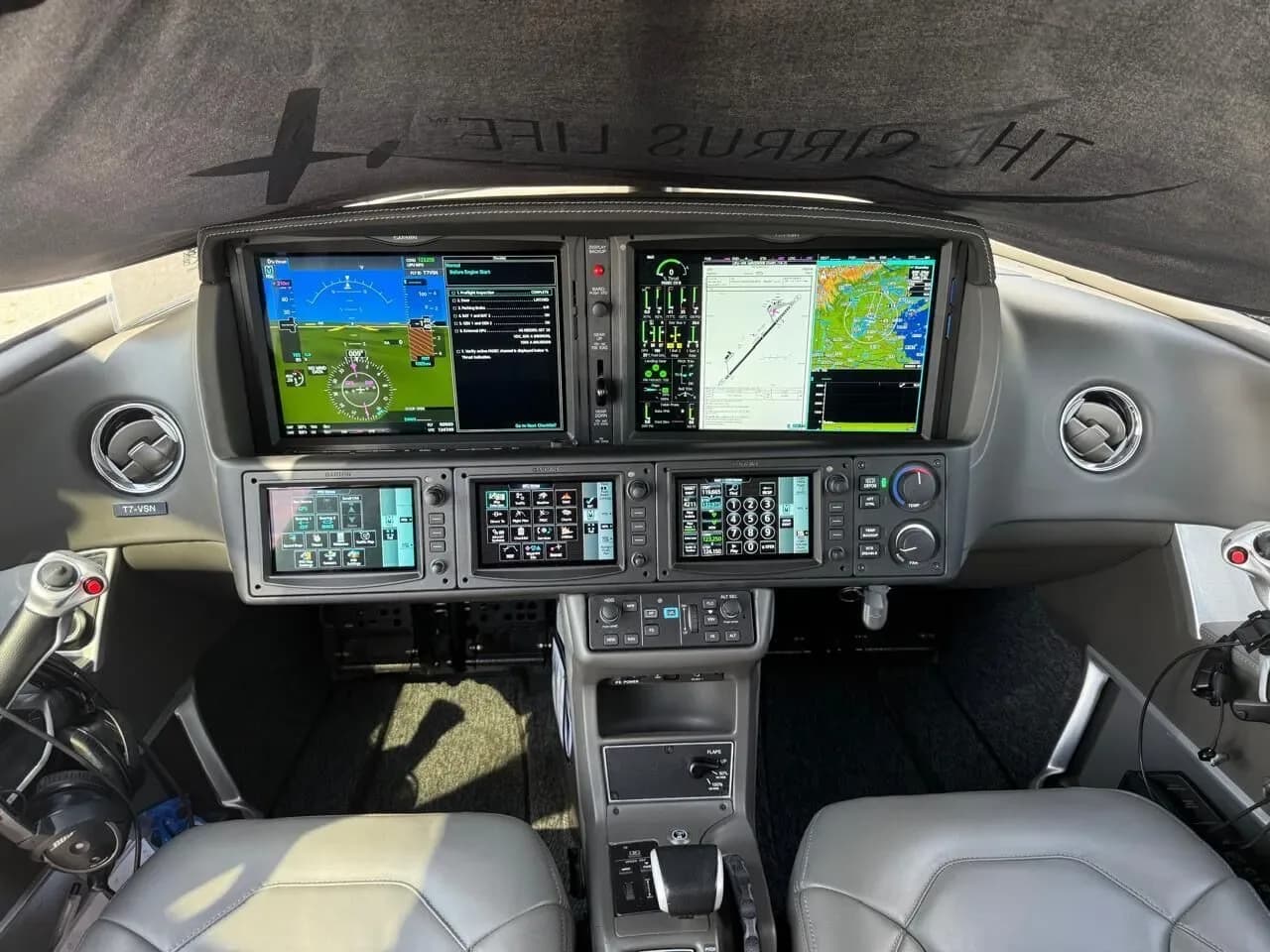 The modern glass cockpit of a Cirrus Vision Jet with multiple display screens and controls.