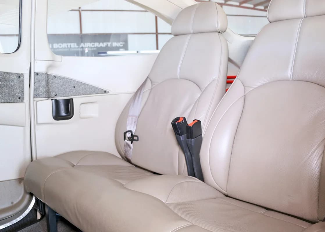 The light tan leather passenger seats in the cabin of the aircraft.
