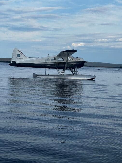 A de Havilland Beaver floatplane is shown on the water.