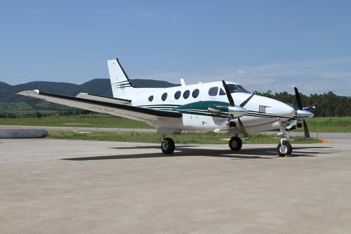 Beechcraft King Air 200 on the tarmac with green and white paint scheme.