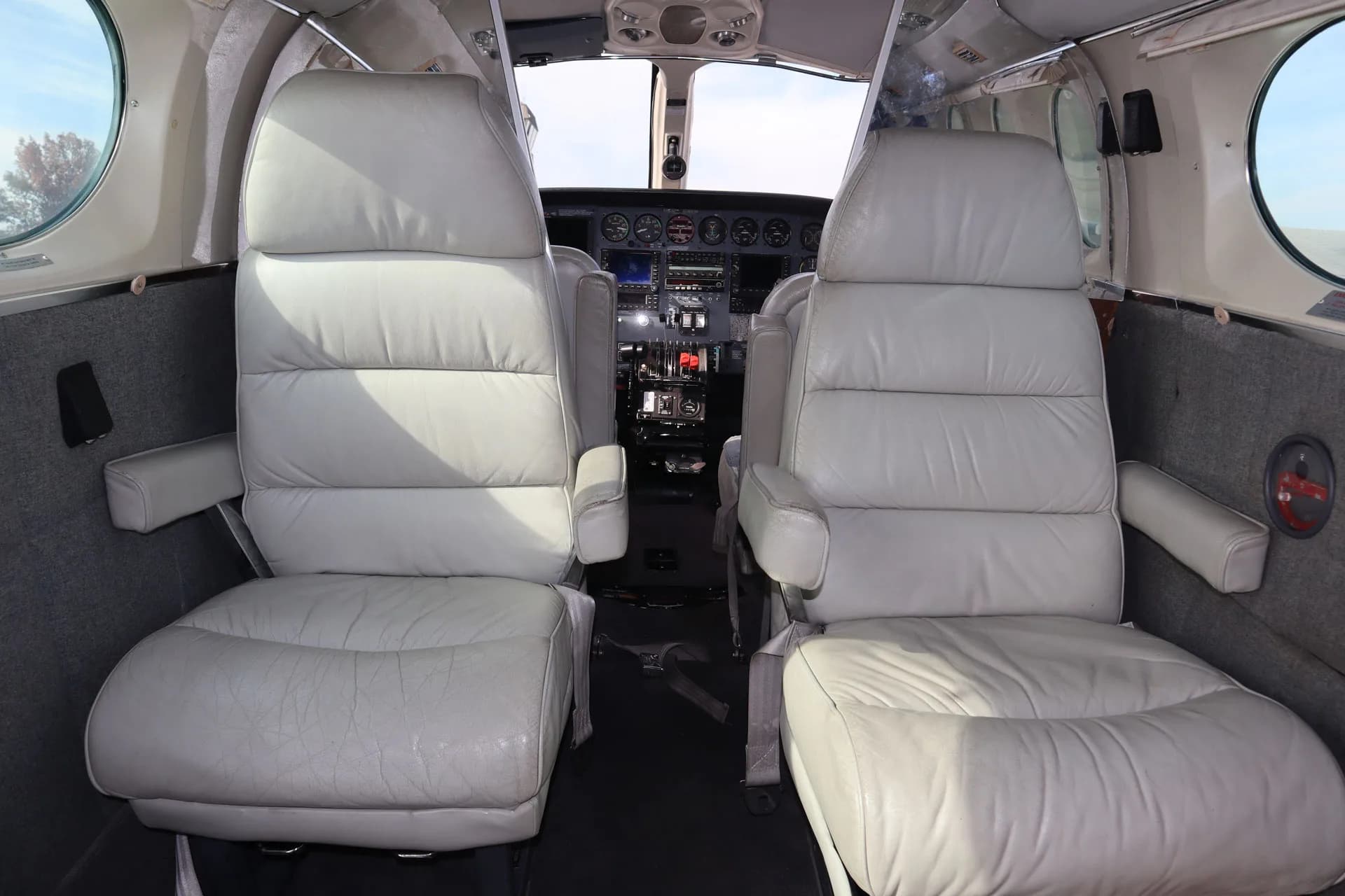 The cockpit of the aircraft is visible from the cabin, showing the instrument panel and seats.