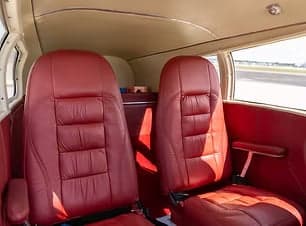 Red leather seats in the cabin of the Piper Apache.