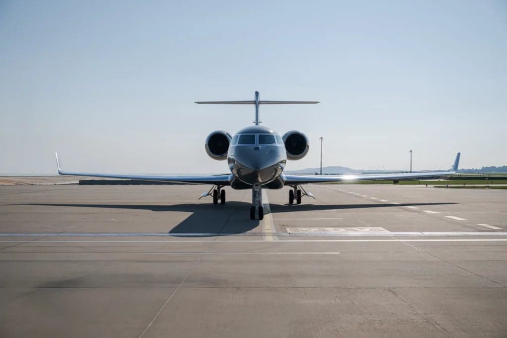 Front view of a gray Gulfstream jet parked on the tarmac.