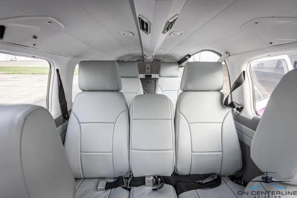 View of the cabin of a Piper PA-32R-301 Saratoga SP, featuring gray leather seats and a gray interior.