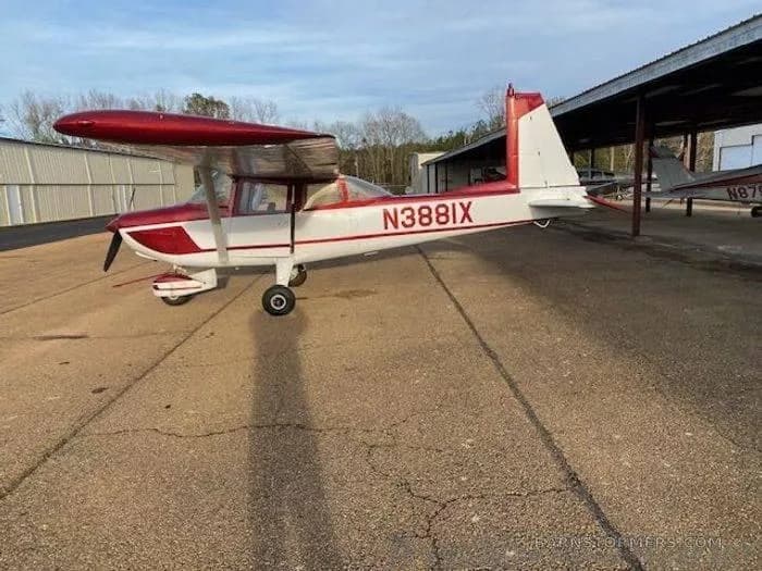 A red and white high-wing single-engine aircraft with registration N388IX parked on an asphalt apron.