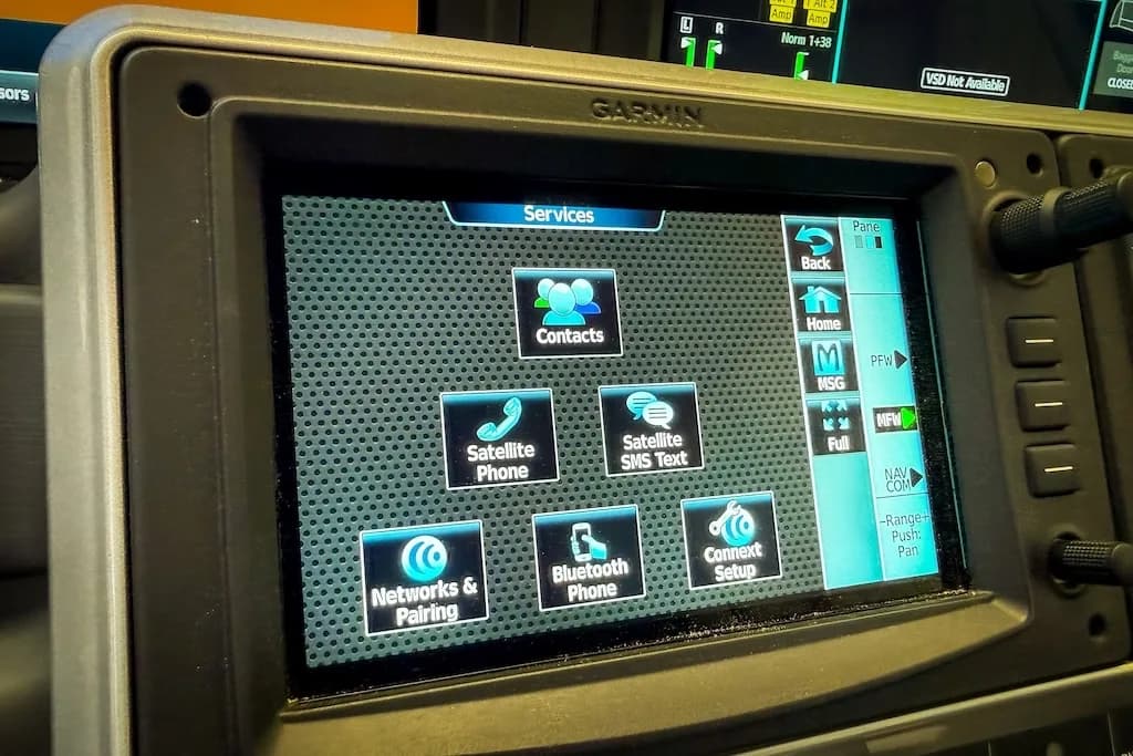 A close-up of a Garmin display screen in the cockpit showing the 'Services' menu.