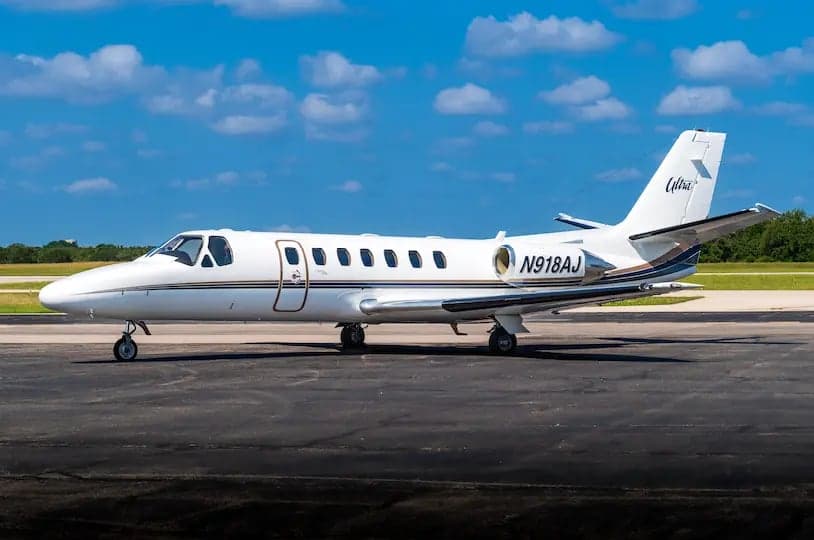 Side view of a white Cessna Citation Ultra with registration N918AJ on the tarmac.