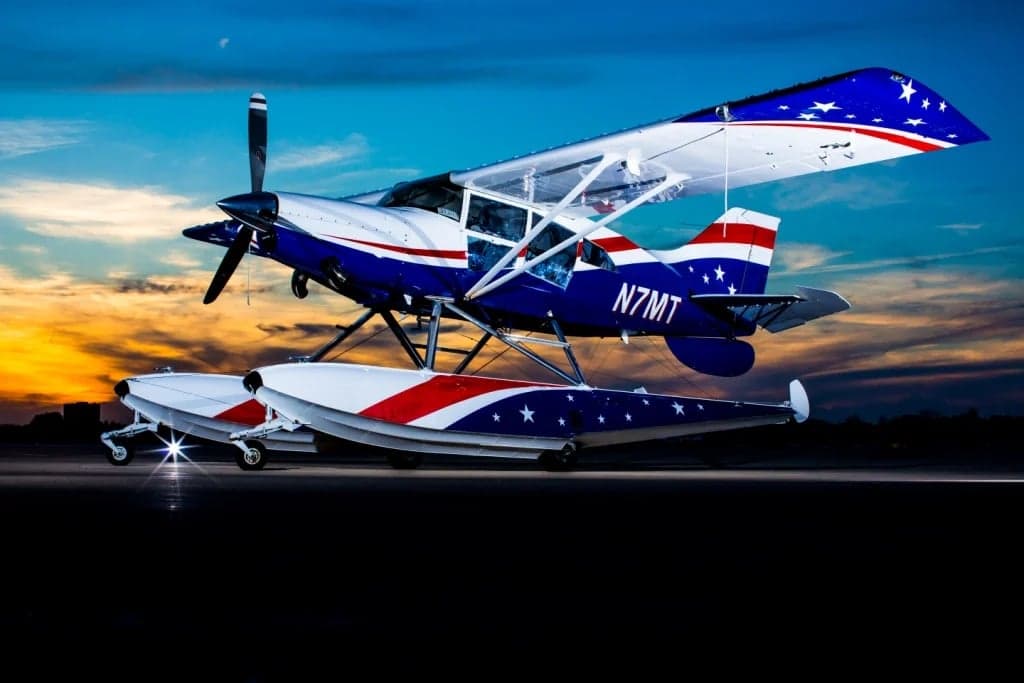 Side view of a blue, white, and red seaplane with stars and stripes paint scheme.