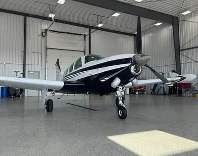 Beechcraft Bonanza in a hangar, front quarter view.
