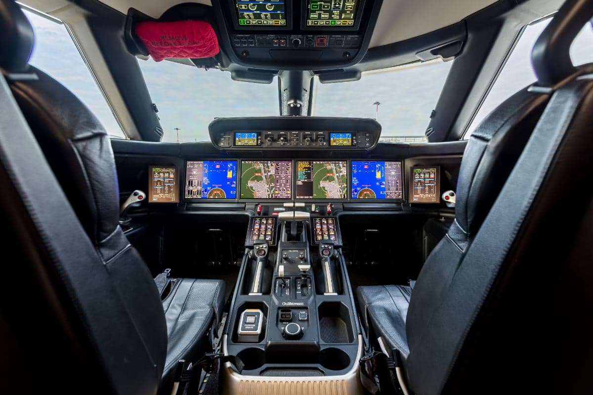 View of the Gulfstream G500 cockpit featuring black leather seats and advanced avionics.