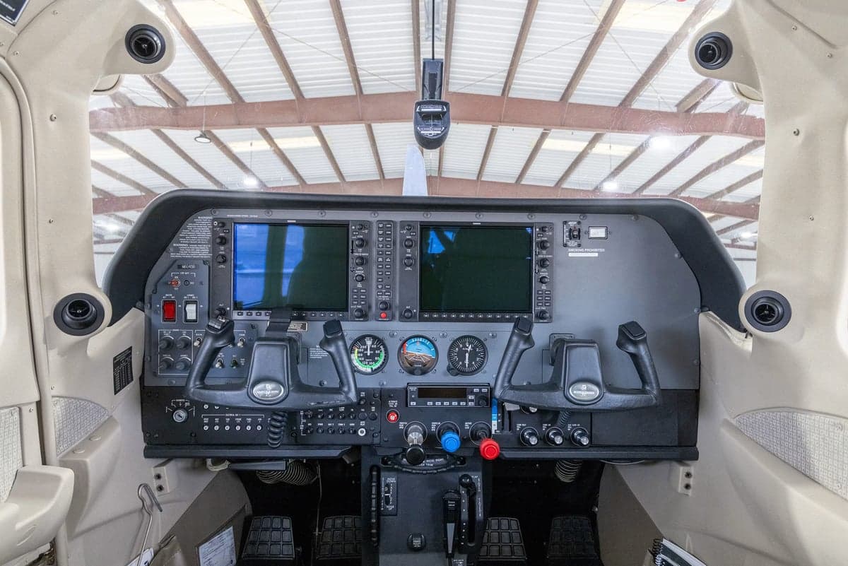 The modern glass cockpit of a Cessna Stationair TC, featuring two large display screens and dual yokes.