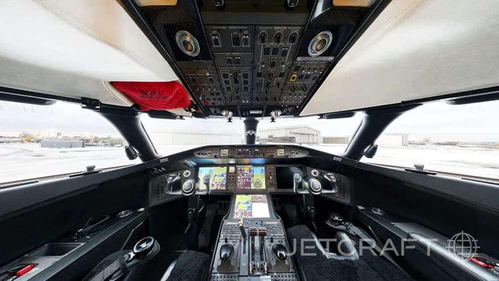 The modern cockpit of a Bombardier Global Express business jet, showing multiple display screens and control panels.