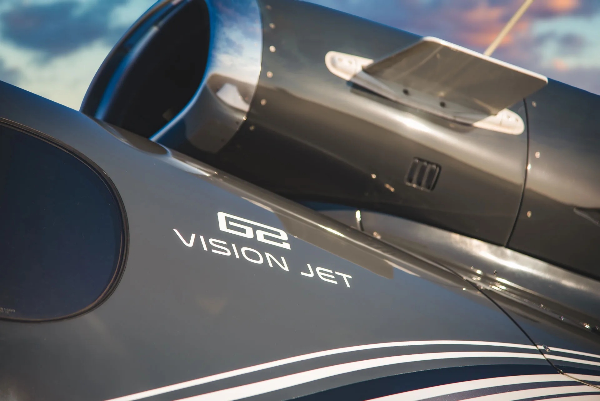 A close-up view of the "G2 VISION JET" logo and engine on the dark grey fuselage of the aircraft.