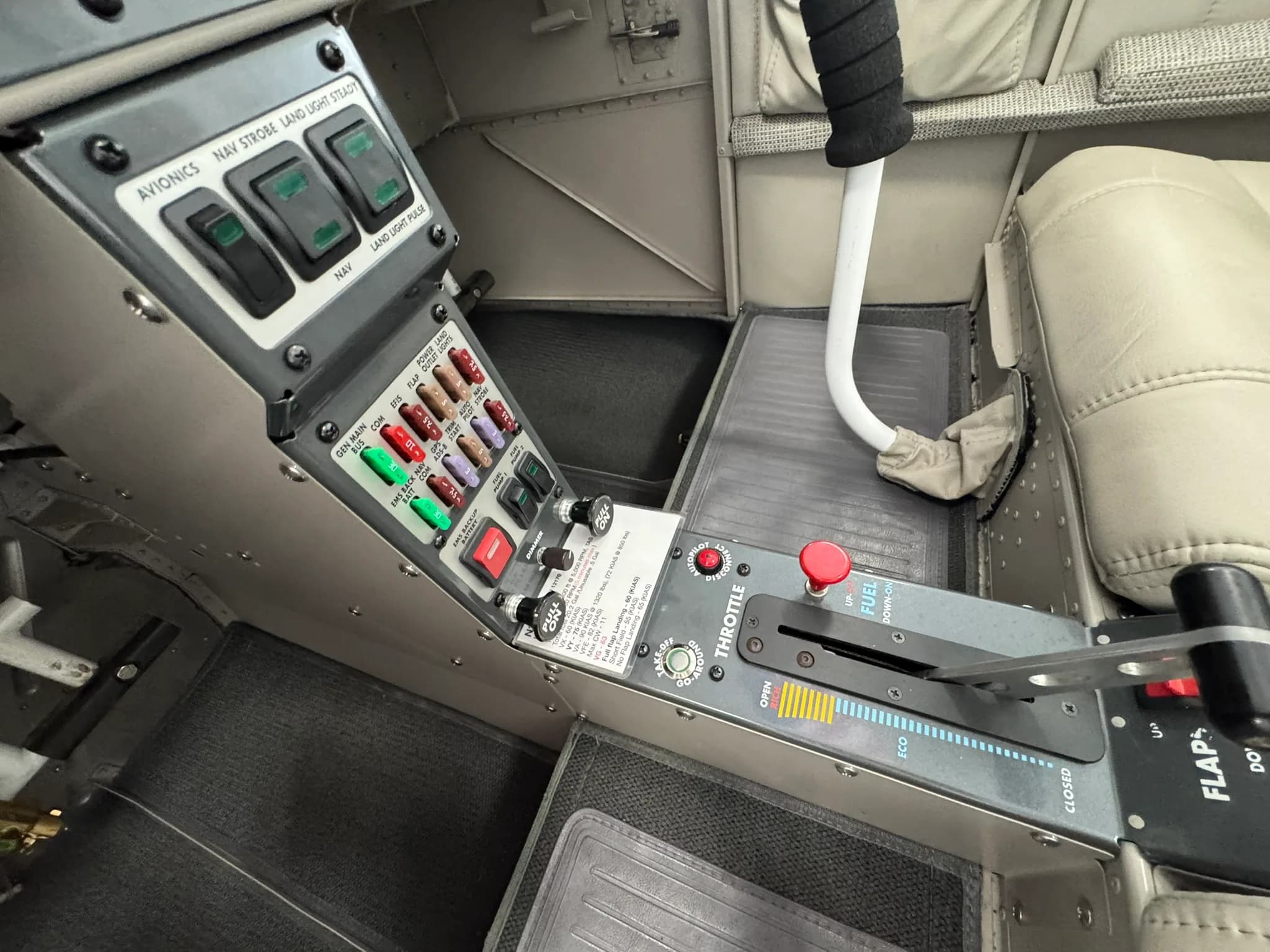A close-up of the aircraft's center console, showing switches, a throttle lever, and flap control.