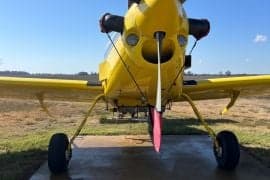 Front view of a yellow agricultural aircraft on the ground.