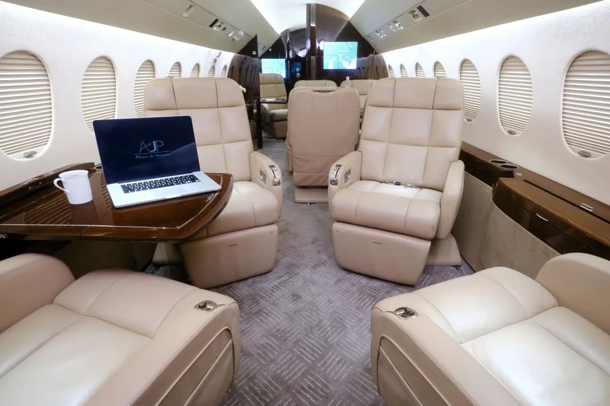 View of the cabin with leather seats, tables, and refreshments.