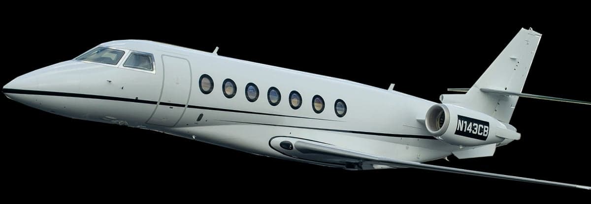Side view of a white Gulfstream jet in flight against a black background.