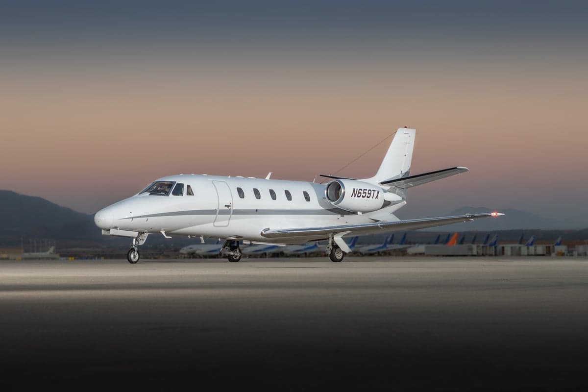 A Citation CJ3+ aircraft on the tarmac at dusk.
