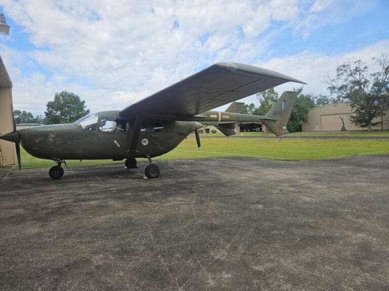 A military-style aircraft with tail number 3048 parked on the tarmac.