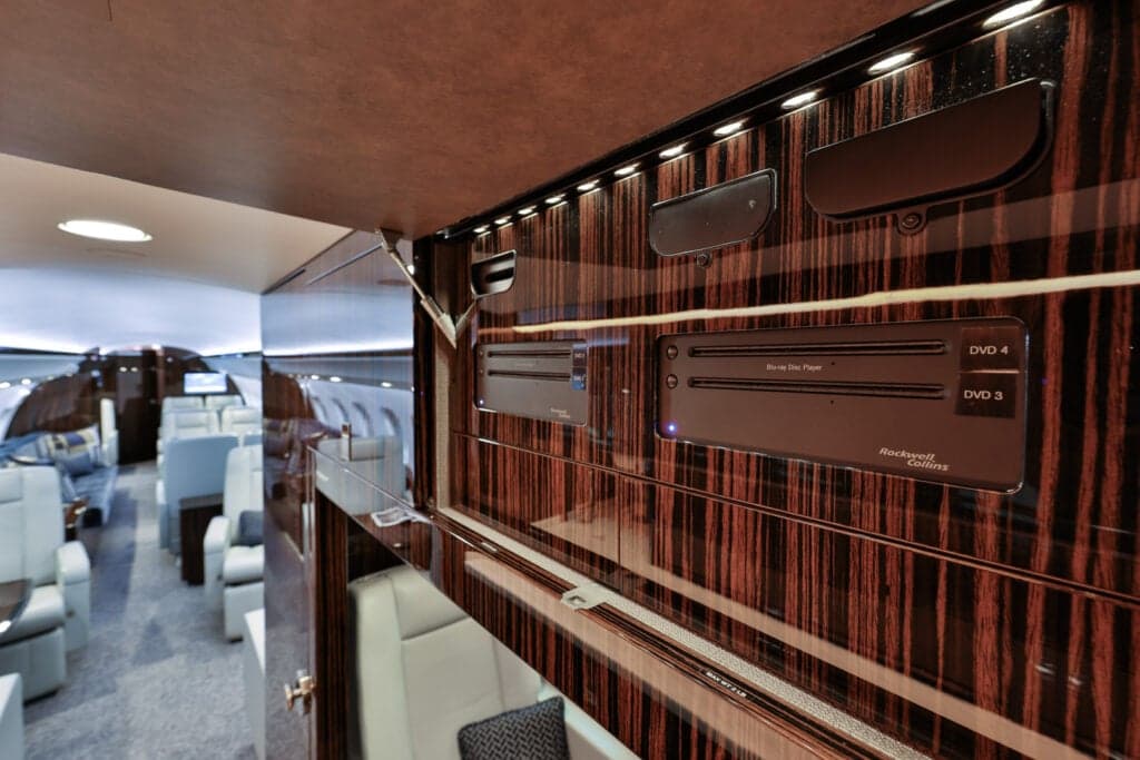 Close-up of the aircraft interior showing a DVD player and wood paneling.