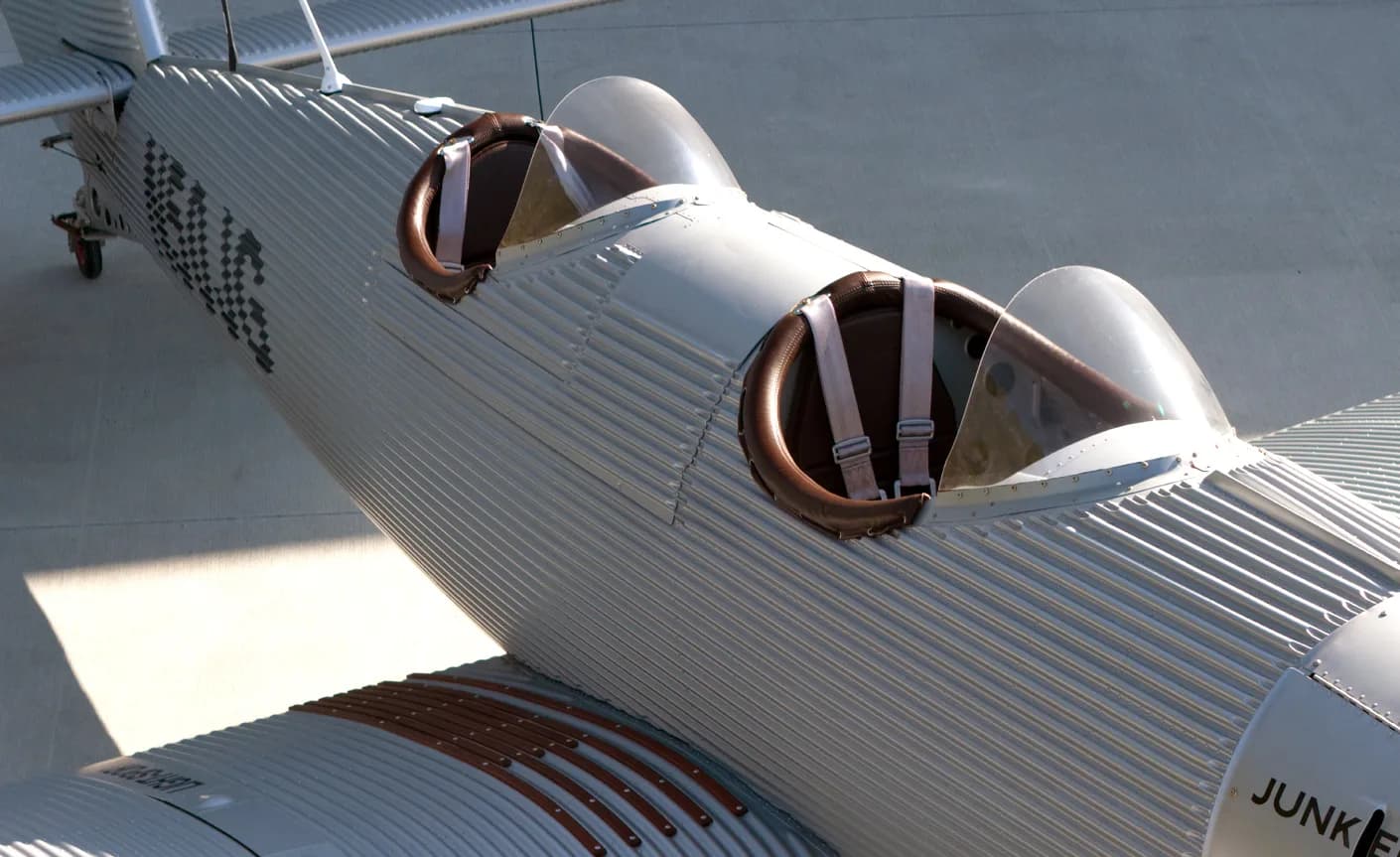 Close-up of the open cockpits of a Junkers aircraft, showing the seats and seatbelts.