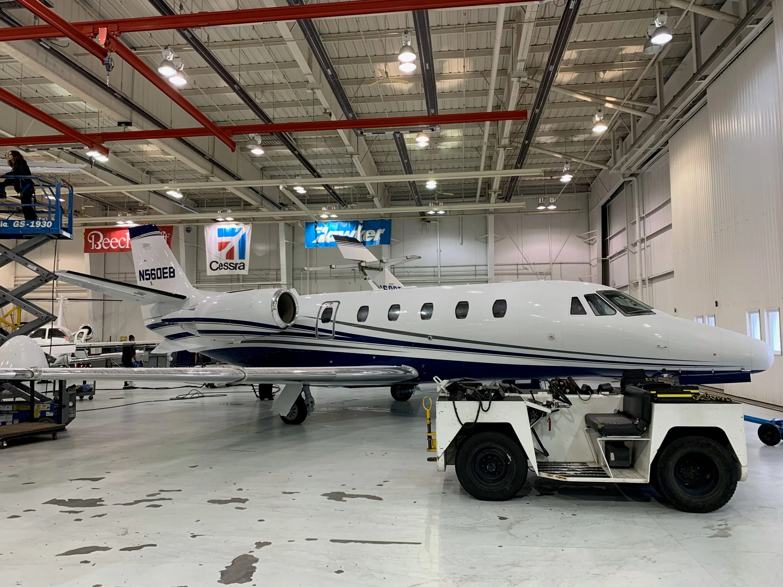 Cessna Citation Excel in a hangar with maintenance equipment.