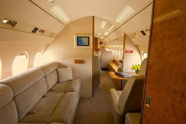 The interior of the aircraft features a sofa and wood accents.