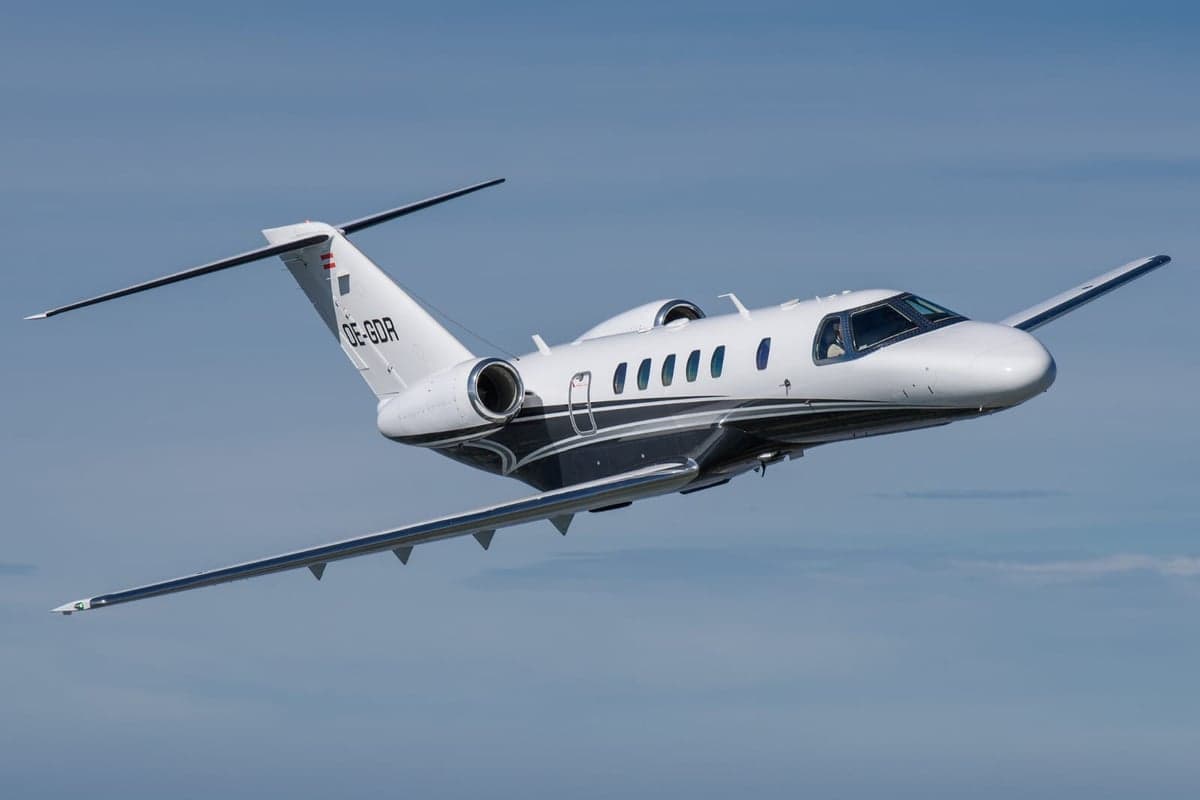 A Cessna Citation CJ2+ aircraft, registration OE-GDR, is shown in flight against a blue sky.