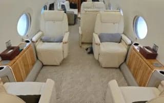 Interior of the aircraft with seats and side tables.