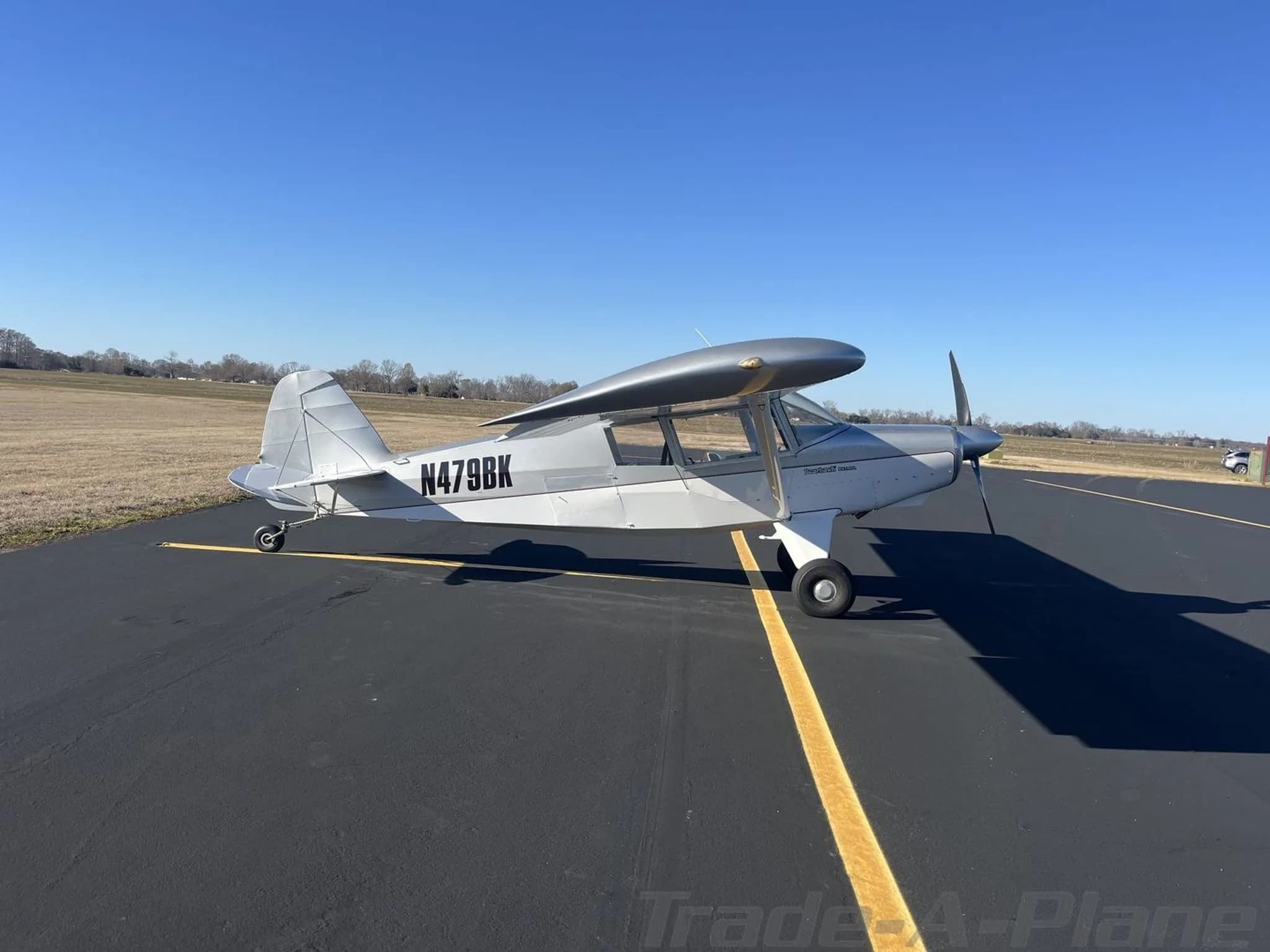 Side view of a silver Bearhawk Patrol aircraft with registration N479BK on an asphalt tarmac.