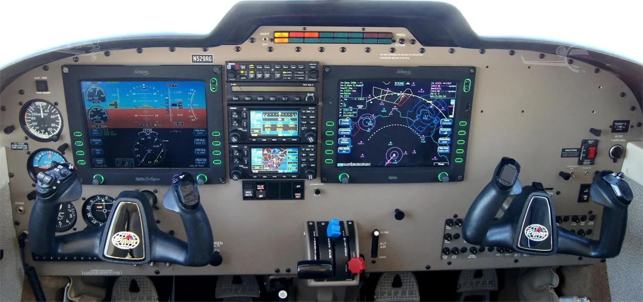 The cockpit instrument panel of the Piper 6XT, featuring multiple digital displays and controls.