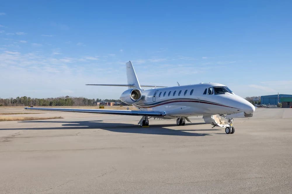 The cockpit of a business jet with multiple digital displays and control yokes.