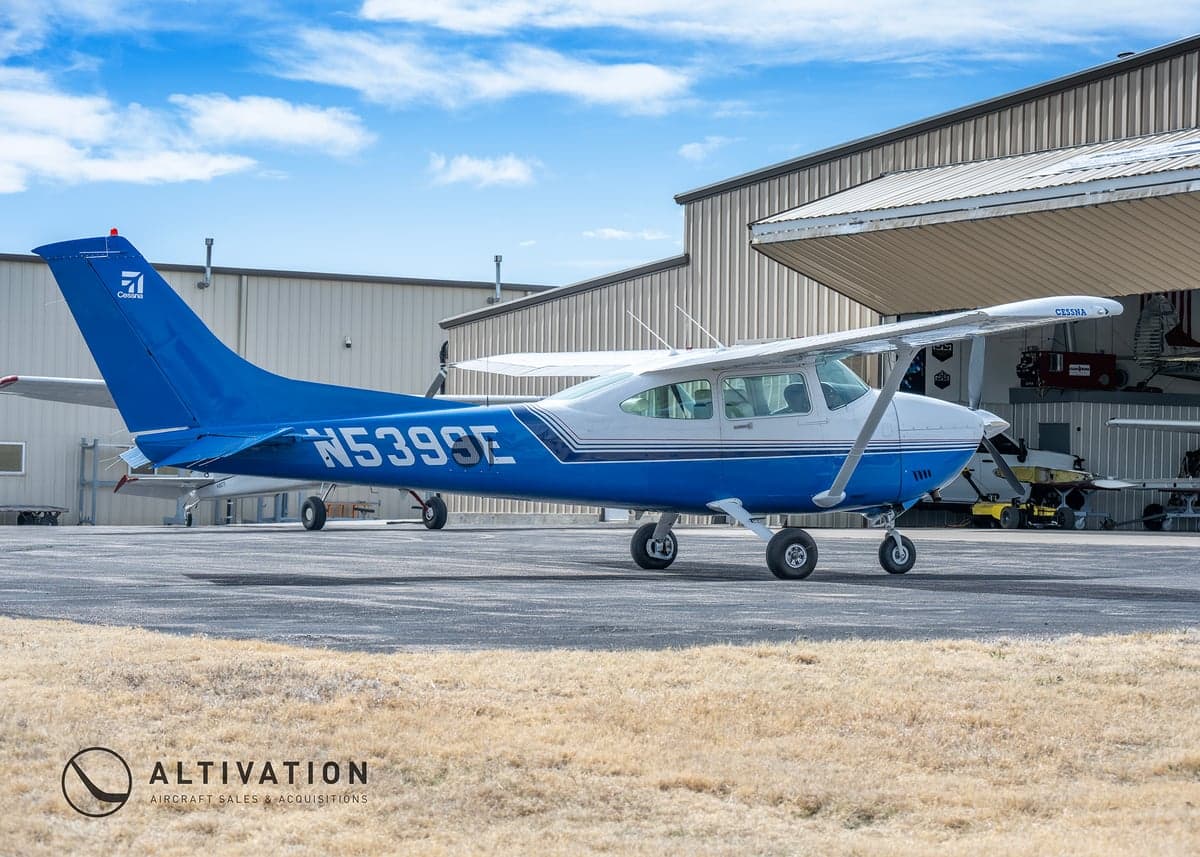 A Cessna aircraft with a blue and white paint scheme parked on the tarmac.