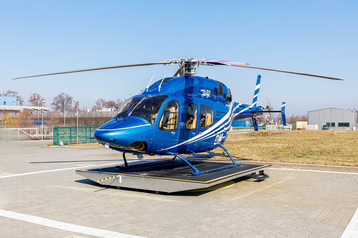A 2012 Bell 429 helicopter with blue and white paint scheme on a platform.
