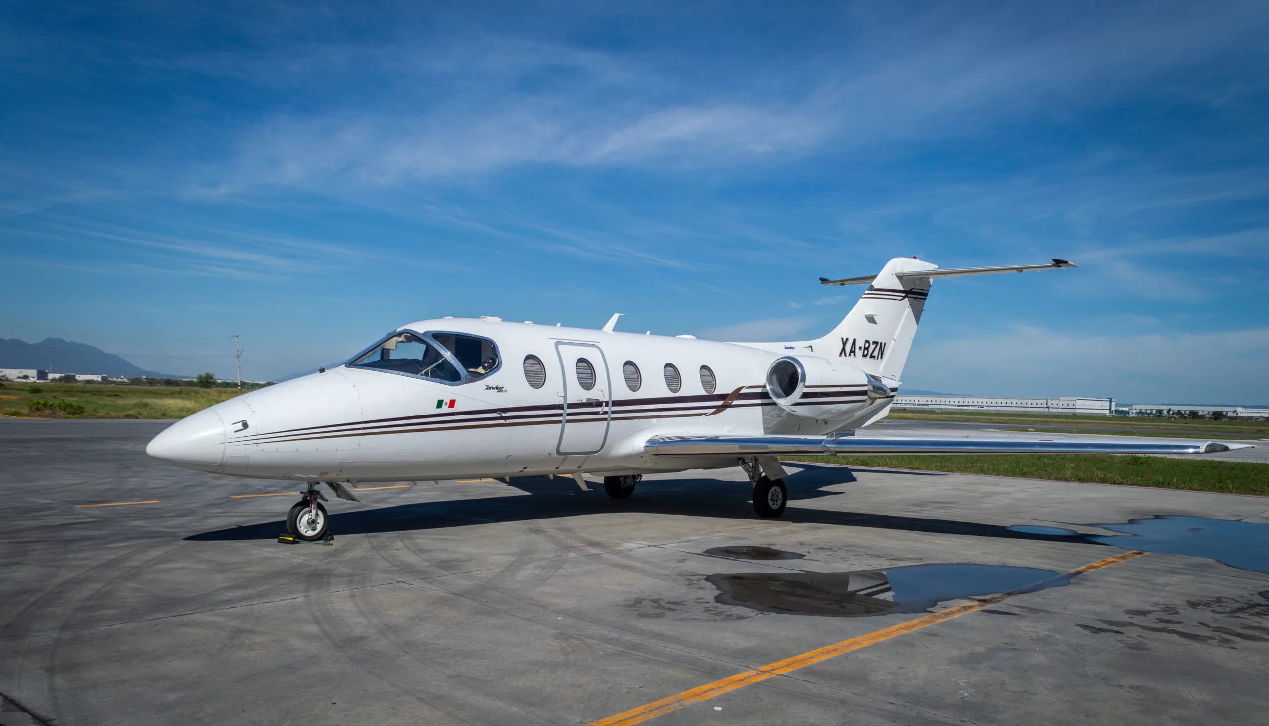 XA-BZN Learjet parked on the tarmac with a white and brown paint scheme.