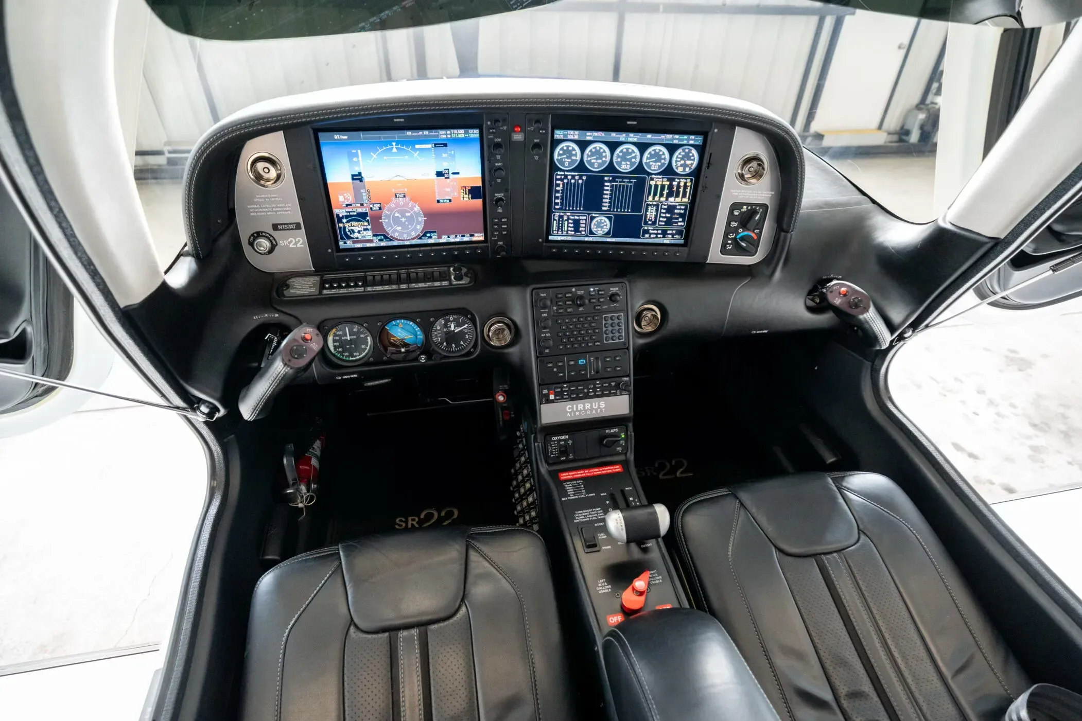 The modern glass cockpit of a Cirrus SR22 aircraft, showing the instrument panel and front seats.