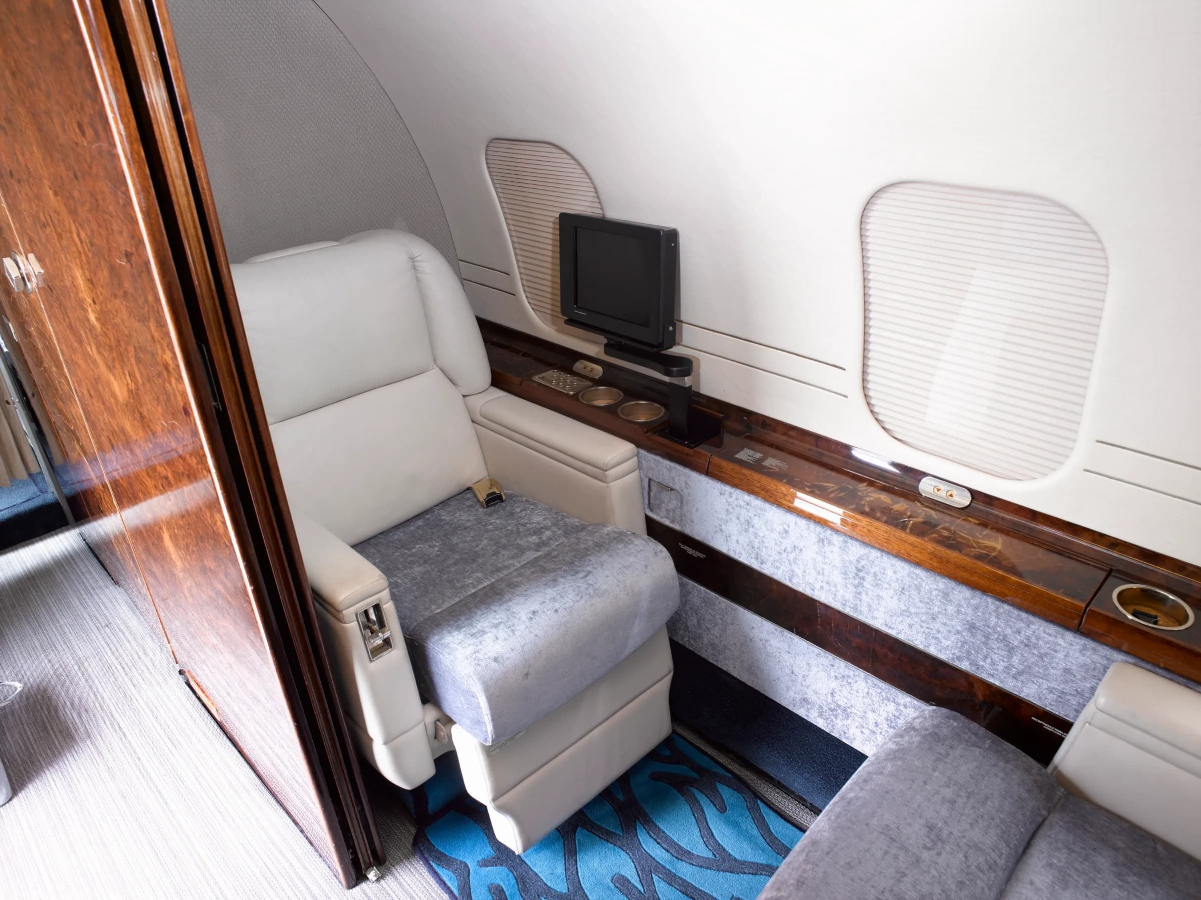 Single seat in the aircraft cabin with a small entertainment screen.