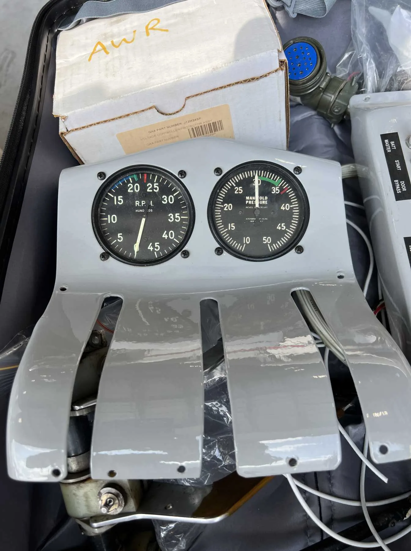 A close-up of two aircraft engine gauges and throttle quadrant components.
